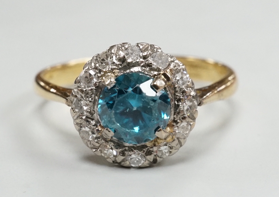 An 18ct & plat, blue zircon and illusion set diamond chip circular cluster ring, size M, gross weight 2.7 grams.